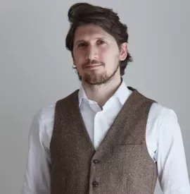 Persona con gilet marrone e camicia bianca.
