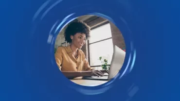 Persona sorridente al computer in una stanza illuminata
