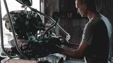 Persona che lavora su un motore in un'officina.