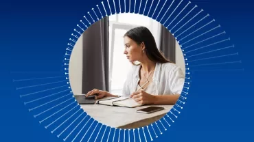 Persona che lavora al computer con un quaderno.