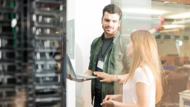 Due persone discutono davanti a un server.
