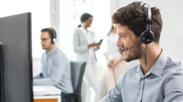 Operatore al computer con cuffia in un ufficio.
