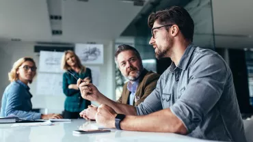 Gruppo di persone in riunione discutendo idee.
