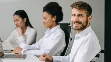 Gruppo di persone al lavoro in ufficio con computer portatili.