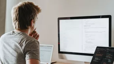 Persona che lavora al computer in un ufficio illuminato.