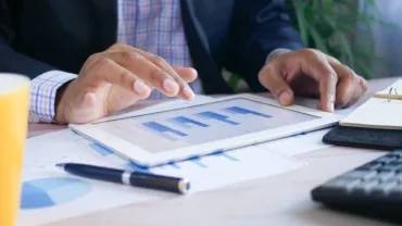 Persona che usa un tablet per analizzare grafici.