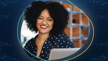Persona sorridente davanti a un laptop, sfondo tecnologico.