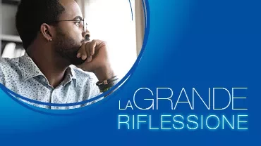 Persona pensierosa guarda fuori dalla finestra, testo 'La grande riflessione'.