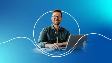 Persona sorridente con laptop su sfondo blu.