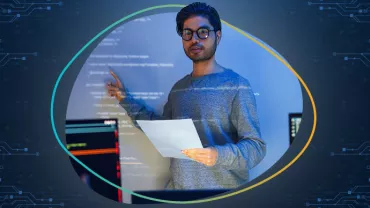 Persona che presenta davanti a uno schermo con codice.