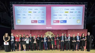 Gruppo di persone premiate su un palco, sfondo con loghi di aziende.