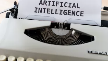 Macchina da scrivere con foglio che dice 'ARTIFICIAL INTELLIGENCE'.