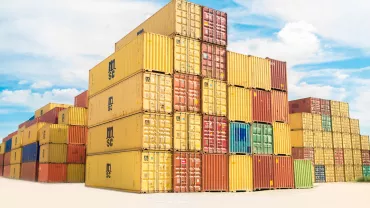 Container impilati in un porto con cielo sereno