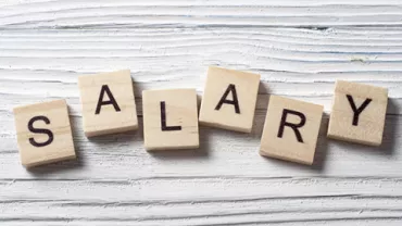 Parola 'SALARY' formata da lettere su dadi di legno.