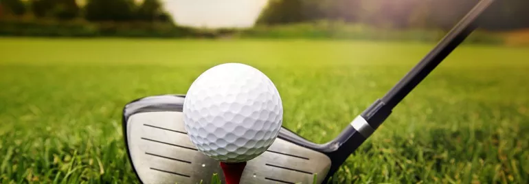 Pallina da golf su tee con mazza in primo piano