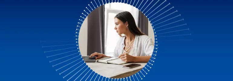 Persona che lavora al computer con un quaderno.
