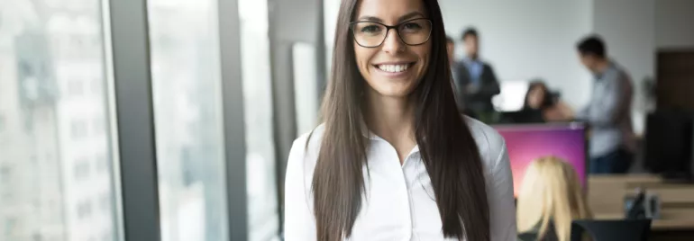 Persona in ufficio, sorridente di fronte alla telecamera