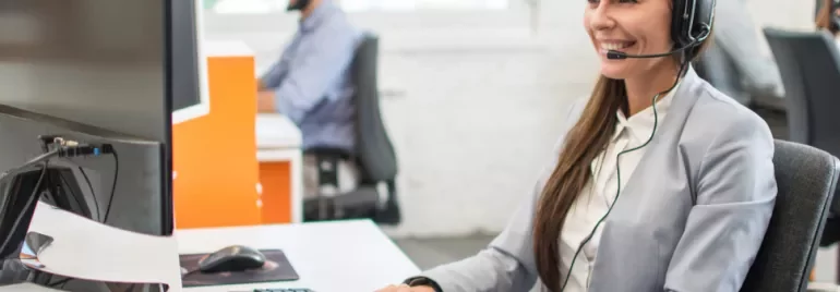 Operatore al computer con cuffie in un ufficio moderno.
