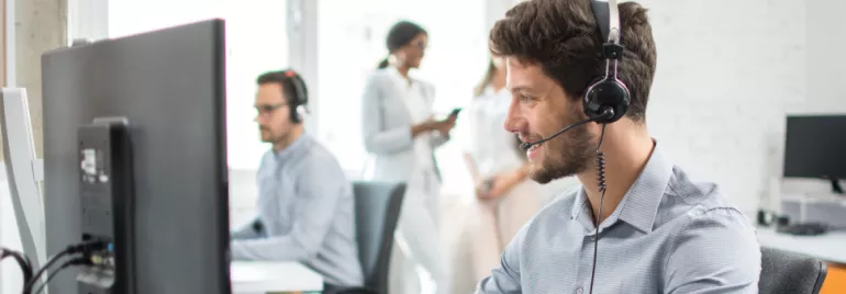 Operatore al computer con cuffia in un ufficio.