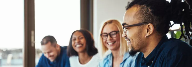 Gruppo di persone che sorridono durante una riunione.
