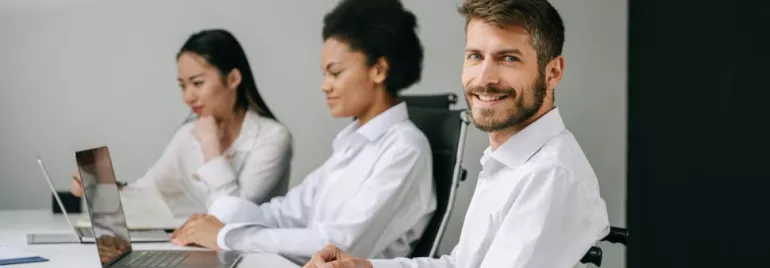 Gruppo di persone al lavoro in ufficio con computer portatili.
