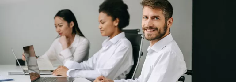 Tre persone lavorano al computer in ufficio.