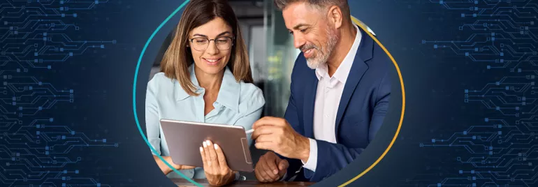 Due persone sorridenti guardano un tablet in un ambiente tecnologico.