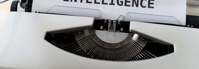 Macchina da scrivere con foglio che dice 'ARTIFICIAL INTELLIGENCE'.