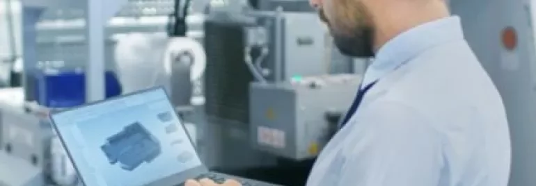 Ingegnere che lavora con un laptop in una fabbrica.