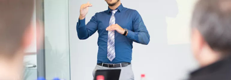 Persona che parla durante una presentazione in ufficio.