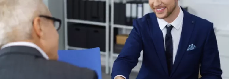 Colloquio di lavoro, stretta di mano tra due persone.