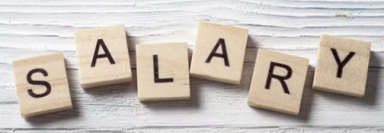 Parola 'SALARY' formata da lettere su dadi di legno.