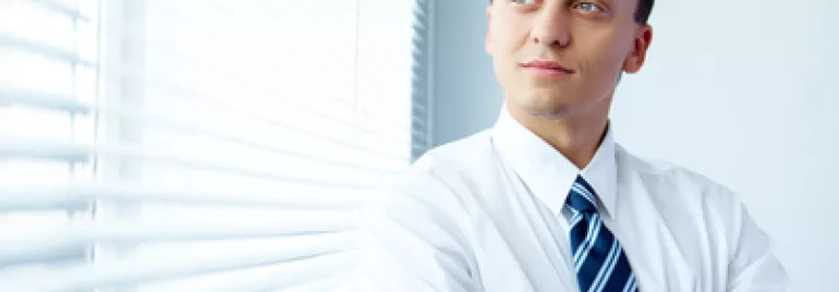 Persona che guarda fuori da una finestra con tende