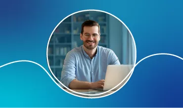 Persona che sorride seduta davanti a un laptop.