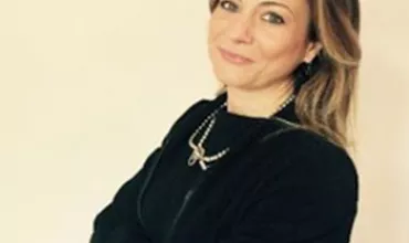 Persona in posa con braccia incrociate e sorriso
