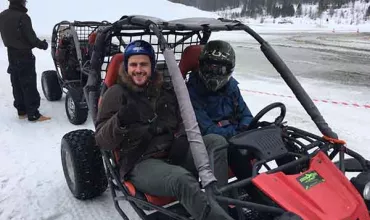 Gruppo di persone su un quad in una pista innevata.